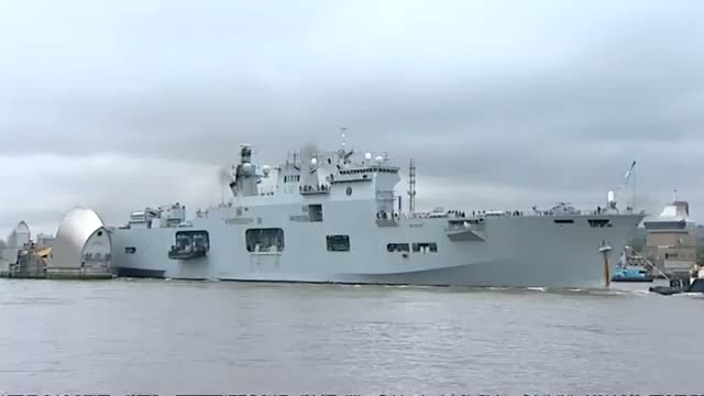 HMS Ocean sails through the Thames Barrier to Greenwich