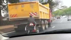 Man in Wheelchair Hanging on to a Truck!