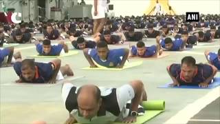 Indian Navy personnel perform yoga asanas on INS Viraat