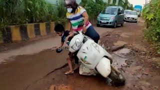 Caught on Camera! Woman falls of the bike with her child trying to dodge pothole