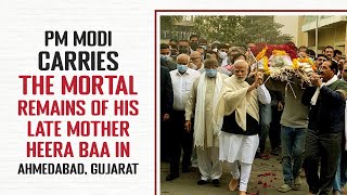 PM Modi carries the mortal remains of his late mother Heera Baa in Ahmedabad, Gujarat