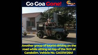 Another group of tourist driving on the road while sitting on top of the SUV at Candolim.