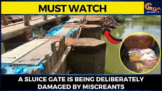 A sluice gate is being deliberately damaged by miscreants.