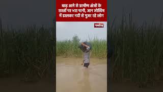 बाढ़ आने से ग्रामीण क्षेत्रों के रास्तों पर भरा पानी, जान जोखिम में डालकर नदी से गुजर रहे लोग